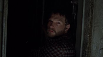 Movie still from “U-571” (2000), directed by Jonathan Mostow – A man in a plaid shirt is looking at the camera; Close Up shot, Low angle