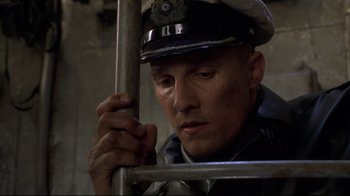 Movie still from “U-571” (2000), directed by Jonathan Mostow – A man in a uniform is holding a metal pole; Close Up shot, Low angle