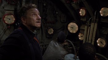 Movie still from “U-571” (2000), directed by Jonathan Mostow – A man looking up into the air in front of a clock; Medium shot, Low angle