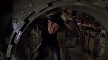 Movie still from “U-571” (2000), directed by Jonathan Mostow – A man wearing a hat and a leather jacket; Medium shot, Overhead angle
