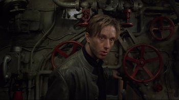 Movie still from “U-571” (2000), directed by Jonathan Mostow – A man standing in front of pipes in a room; Close Up shot, Low angle