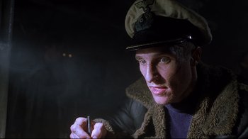 Movie still from “U-571” (2000), directed by Jonathan Mostow – A man wearing a hat and holding a cigarette in his hand; Close Up shot, Low angle