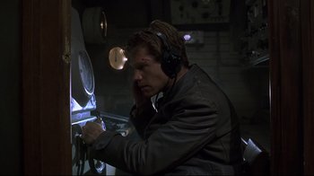 Movie still from “U-571” (2000), directed by Jonathan Mostow – A man wearing headphones is looking at a clock; Close Up shot, Low angle