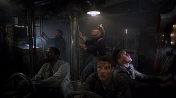 Movie still from “U-571” (2000), directed by Jonathan Mostow – A group of men sitting in front of a light pole; Medium shot, Low angle