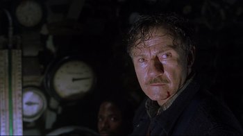 Movie still from “U-571” (2000), directed by Jonathan Mostow – A person with a clock in the background; Close Up shot, Low angle