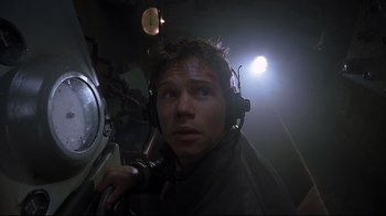 Movie still from “U-571” (2000), directed by Jonathan Mostow – A man with headphones on looking at the camera; Close Up shot, Low angle