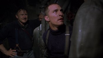Movie still from “U-571” (2000), directed by Jonathan Mostow – A man looking up into the air while another man looks on; Medium shot, Low angle