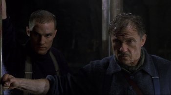 Movie still from “U-571” (2000), directed by Jonathan Mostow – A man and a man standing next to each other in the dark; Medium shot, Low angle