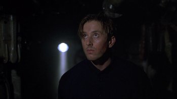 Movie still from “U-571” (2000), directed by Jonathan Mostow – A man in a black shirt is looking up at the ceiling; Close Up shot, Low angle