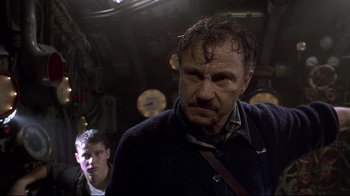 Movie still from “U-571” (2000), directed by Jonathan Mostow – A man in a black jacket is looking at the camera; Medium shot, Low angle