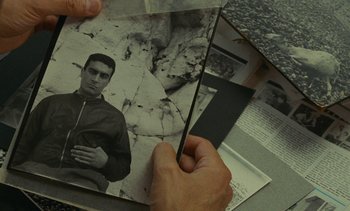 Movie still from “Ulysse” (1983), directed by Agnès Varda – A person holding an old photo of a man; Close Up shot, High angle