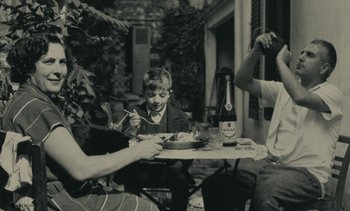 Movie still from “Ulysse” (1983), directed by Agnès Varda – A group of people sitting at a table eating food; Medium shot, High angle