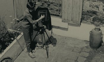 Movie still from “Ulysse” (1983), directed by Agnès Varda – An old photo of a person taking a picture; Wide shot, High angle