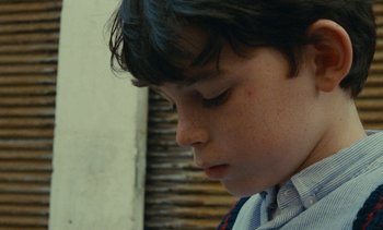 Movie still from “Ulysse” (1983), directed by Agnès Varda – A young boy's face looking down; Close Up shot, High angle