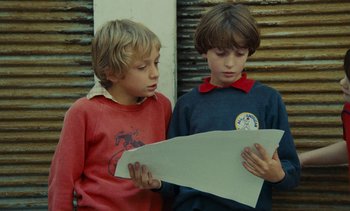 Movie still from “Ulysse” (1983), directed by Agnès Varda – Two young boys looking at a piece of paper; Medium shot, Over the shoulder angle