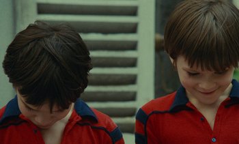Movie still from “Ulysse” (1983), directed by Agnès Varda – Two young boys in red and blue striped shirts; Close Up shot, High angle