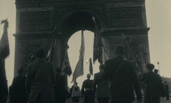 Movie still from “Ulysse” (1983), directed by Agnès Varda – A black and white photo of a group of people walking under a arch; Extreme Wide shot, High angle