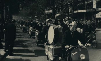Movie still from “Ulysse” (1983), directed by Agnès Varda – A black and white photo of people on motorcycles in a parade; Extreme Wide shot, High angle