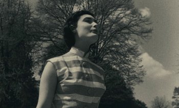 Movie still from “Ulysse” (1983), directed by Agnès Varda – A woman standing in front of a large tree; Close Up shot, Low angle