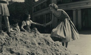 Movie still from “Ulysse” (1983), directed by Agnès Varda – An old photo of a woman and a child playing in the sand; Wide shot, High angle
