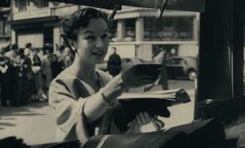 Movie still from “Ulysse” (1983), directed by Agnès Varda – An old photo of a woman holding papers in her hands; Medium shot, Low angle