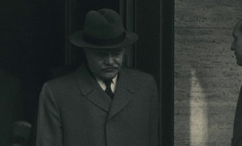 Movie still from “Ulysse” (1983), directed by Agnès Varda – An older man wearing a suit and a hat; Close Up shot, Over the shoulder angle