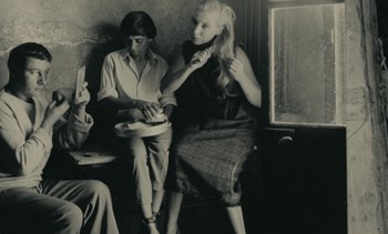 Movie still from “Ulysse” (1983), directed by Agnès Varda – Two women are sitting on a bench and one is holding a plate; Medium shot, High angle