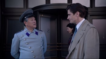 Movie still from “Unbroken: Path to Redemption” (2018), directed by Harold Cronk – A man in a suit talking to another man in a suit; Medium shot, Over the shoulder angle