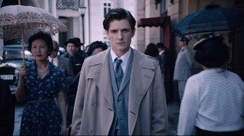 Movie still from “Unbroken: Path to Redemption” (2018), directed by Harold Cronk – A man in a suit and tie standing in front of a crowd; Medium shot, Over the shoulder angle