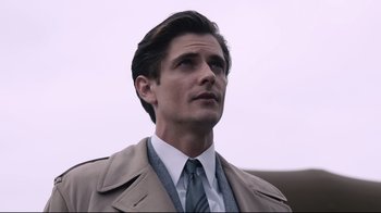 Movie still from “Unbroken: Path to Redemption” (2018), directed by Harold Cronk – A man wearing a suit and tie looking up; Close Up shot, Low angle
