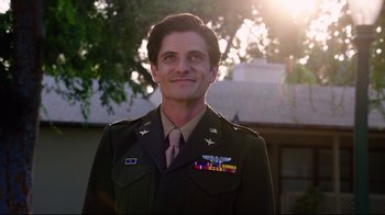 Movie still from “Unbroken: Path to Redemption” (2018), directed by Harold Cronk – A man in a military uniform smiling for the camera; Medium shot, Low angle
