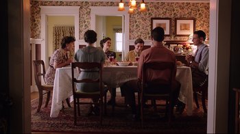Movie still from “Unbroken: Path to Redemption” (2018), directed by Harold Cronk – A group of people sitting around a table eating dinner; Wide shot, High angle