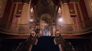 Movie still from “Unbroken: Path to Redemption” (2018), directed by Harold Cronk – A man standing on the stairs of a large building; Extreme Wide shot, Low angle