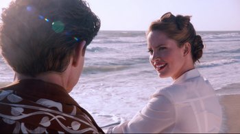 Movie still from “Unbroken: Path to Redemption” (2018), directed by Harold Cronk – A man and a woman on the beach by the water; Medium shot, Over the shoulder angle