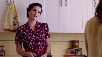 Movie still from “Unbroken: Path to Redemption” (2018), directed by Harold Cronk – A woman standing in a kitchen wearing a floral shirt; Medium shot, Over the shoulder angle