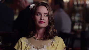 Movie still from “Unbroken: Path to Redemption” (2018), directed by Harold Cronk – A woman with a flower in her hair and a yellow dress; Close Up shot, Over the shoulder angle