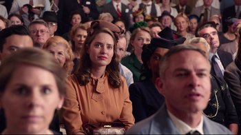 Movie still from “Unbroken: Path to Redemption” (2018), directed by Harold Cronk – A crowd of people sitting and standing in a room; Close Up shot, Over the shoulder angle