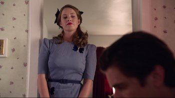 Movie still from “Unbroken: Path to Redemption” (2018), directed by Harold Cronk – A woman in a blue dress standing in front of a mirror; Medium shot, Low angle