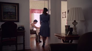 Movie still from “Unbroken: Path to Redemption” (2018), directed by Harold Cronk – A man and a woman standing in a living room next to each other; Wide shot, Low angle