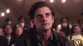 Movie still from “Unbroken: Path to Redemption” (2018), directed by Harold Cronk – A person wearing a brown jacket; Close Up shot, Low angle