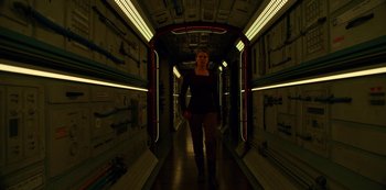 Movie still from “Another Life” (2019), created by Aaron Martin – A woman walking down a hallway in a building; Wide shot, Low angle