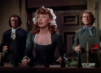 Movie still from “Unconquered” (1947), directed by Cecil B. DeMille – A group of people standing next to each other in a room; Medium shot, Low angle