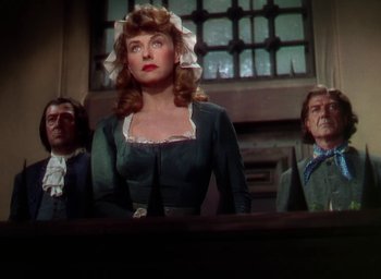Movie still from “Unconquered” (1947), directed by Cecil B. DeMille – A group of people standing in front of a window; Medium shot, Low angle