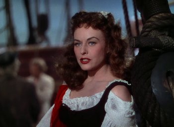 Movie still from “Unconquered” (1947), directed by Cecil B. DeMille – A beautiful woman with long curly red hair and red lipstick; Close Up shot, Over the shoulder angle