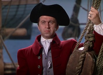 Movie still from “Unconquered” (1947), directed by Cecil B. DeMille – A man wearing a pirate hat and a red jacket; Medium shot, Low angle