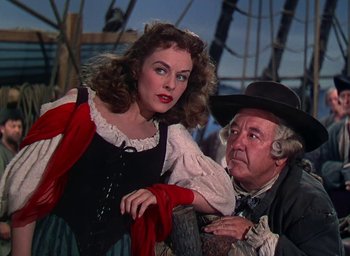 Movie still from “Unconquered” (1947), directed by Cecil B. DeMille – A man and a woman are sitting next to each other on a boat; Medium shot, Over the shoulder angle