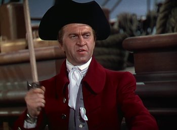 Movie still from “Unconquered” (1947), directed by Cecil B. DeMille – A man in a red jacket and a hat holding a sword; Medium shot, Over the shoulder angle