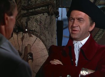 Movie still from “Unconquered” (1947), directed by Cecil B. DeMille – A man wearing a red jacket and a black hat; Medium shot, Over the shoulder angle