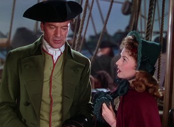 Movie still from “Unconquered” (1947), directed by Cecil B. DeMille – A man and a woman in a pirate costume on a boat; Medium shot, Over the shoulder angle