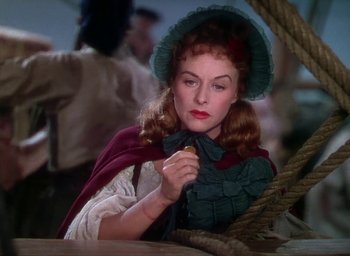 Movie still from “Unconquered” (1947), directed by Cecil B. DeMille – A woman with a red cape and a green hat; Close Up shot, High angle
